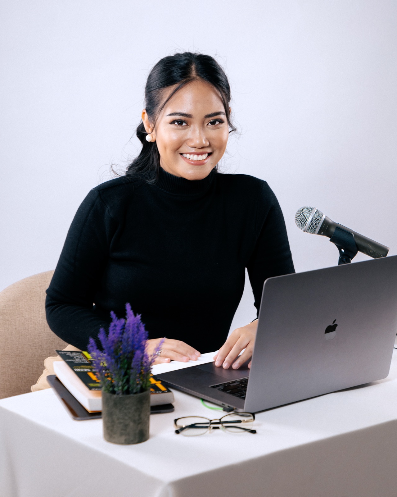 Demi Bernice at her desk with a laptop and microphone